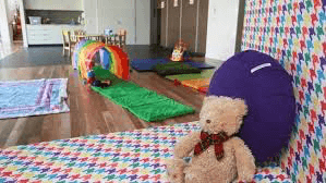 One Light Charity image of a colourful child bedroom in a hospice decorated with toys and teddy bear on bed