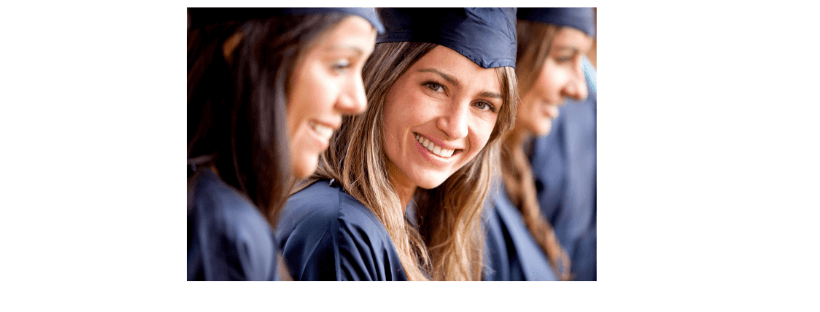 Young girls smiling dressed in graduation gowns