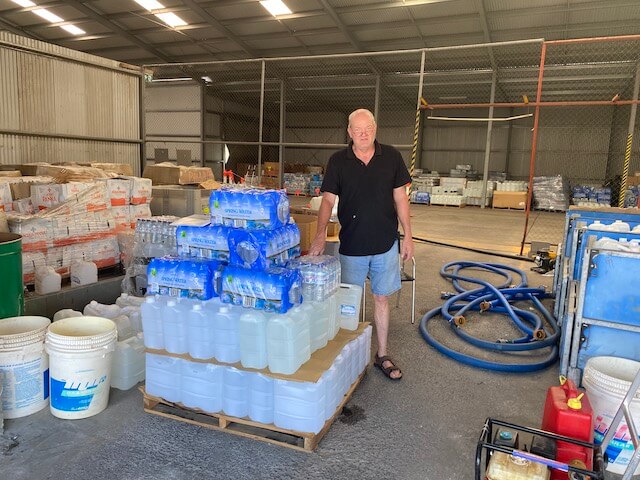 Man in black shirt standing in front of water donation
