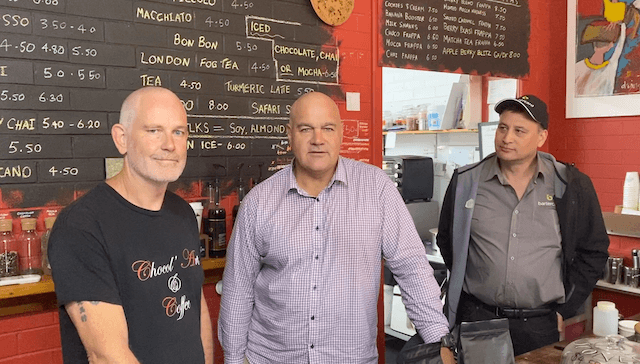 Three men stand-in in coffee shop