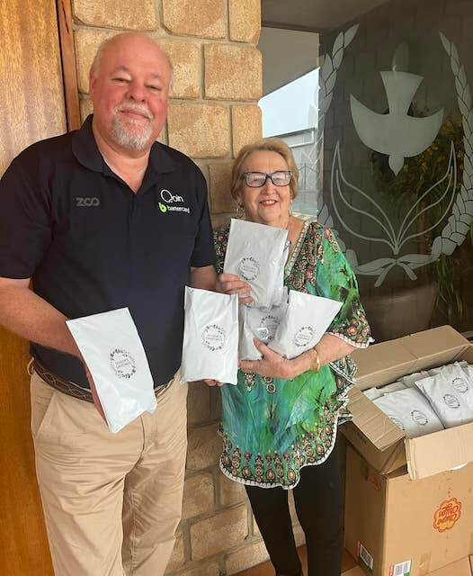 One Light donor donates gift packs to older lady in gree shirt