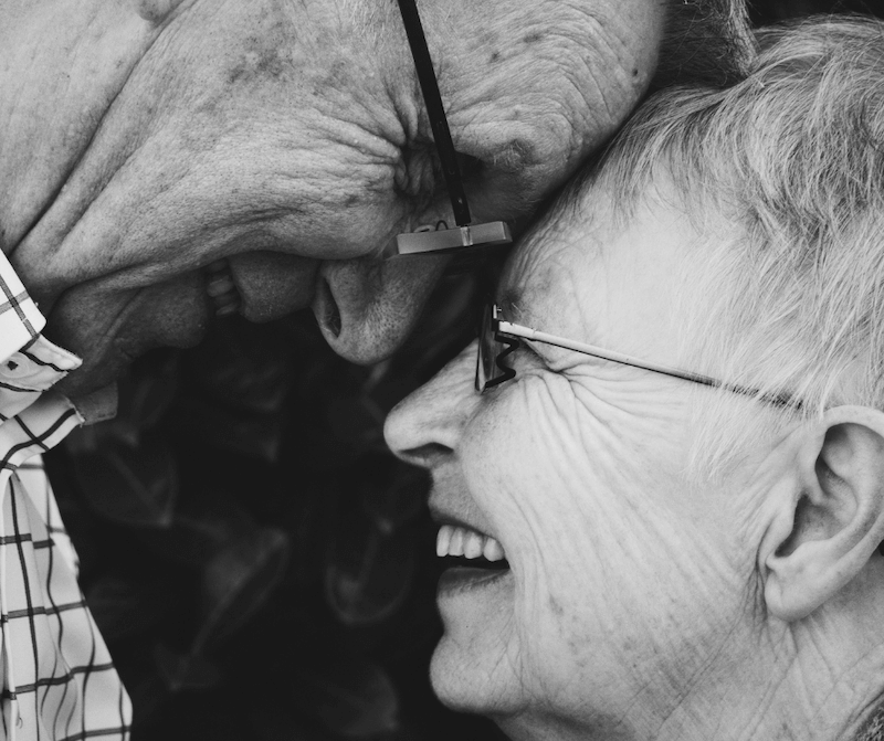 Pensioner couple smiling at each other