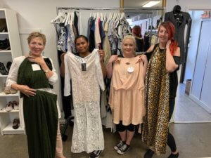 4 women showing dresses in a clothing shop