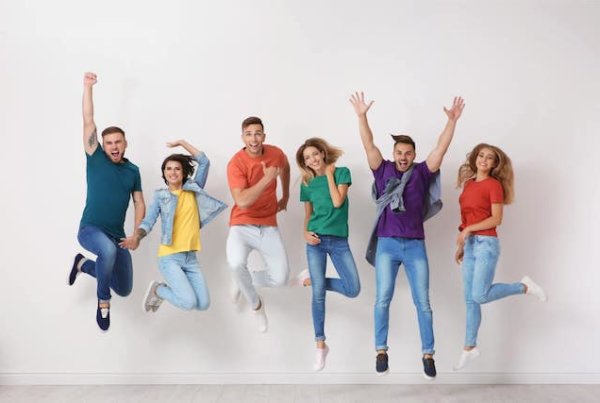 Young people wearing bright colours jumping in the air