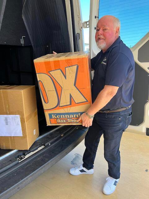 Man dressed in blue delivering a big box